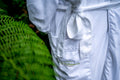 Island Currents Spa white robe with a brand logo on a green leafy background