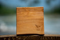 Wooden cutting board with engraved Sonora Resort logo on a blurred natural background