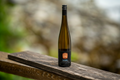 A bottle of Old Vines Tantalus riesling sitting on a wooden board with a blurred natural background, at Sonora Resort.