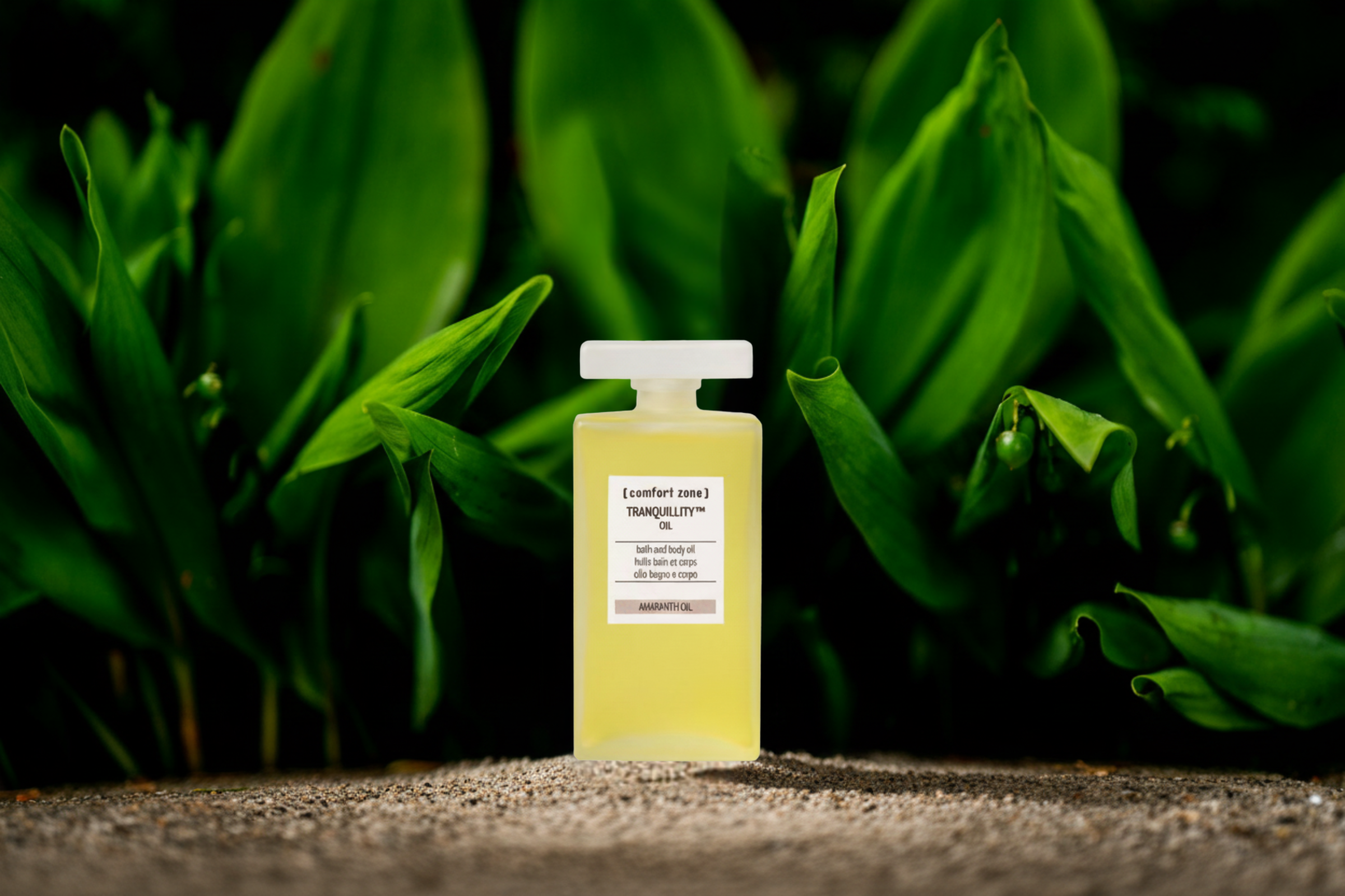 A bottle of Tranquility Oil - bath and body oil - with a dark leafy green background
